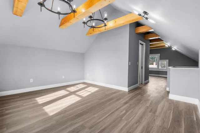 a view of a room with wooden floor and an entryway