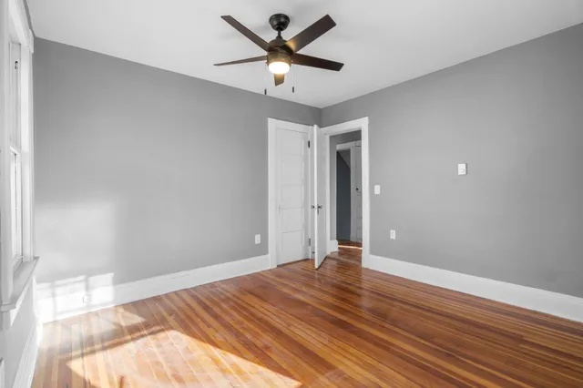 a view of a room with wooden floor and a ceiling fan