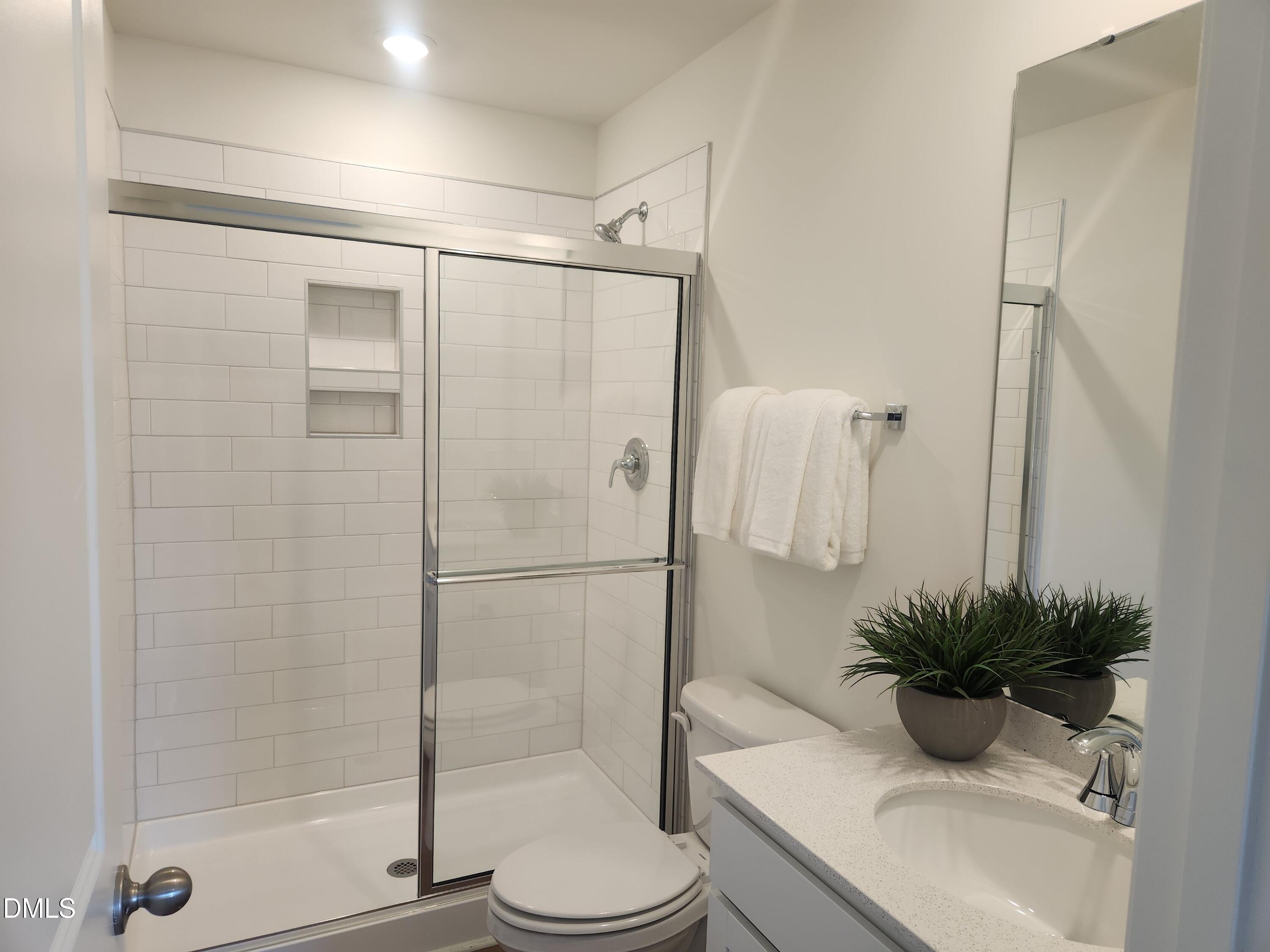 2204 Rabbitbrush Street Durham, NC 27704 - Photo 11 of 21 a bathroom with a shower a toilet and a sink