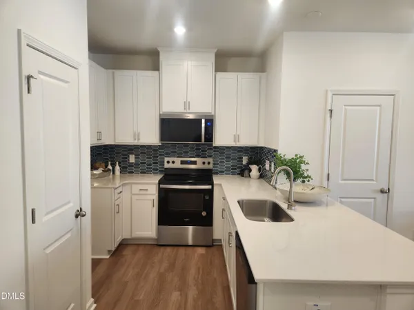 a kitchen with a sink a stove and cabinets