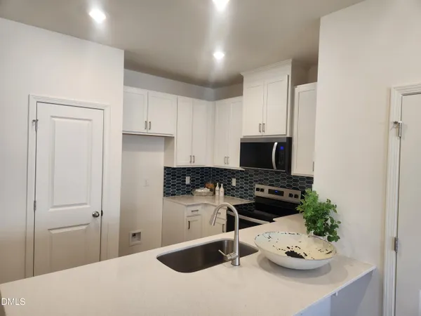 a kitchen with a refrigerator and a stove top oven