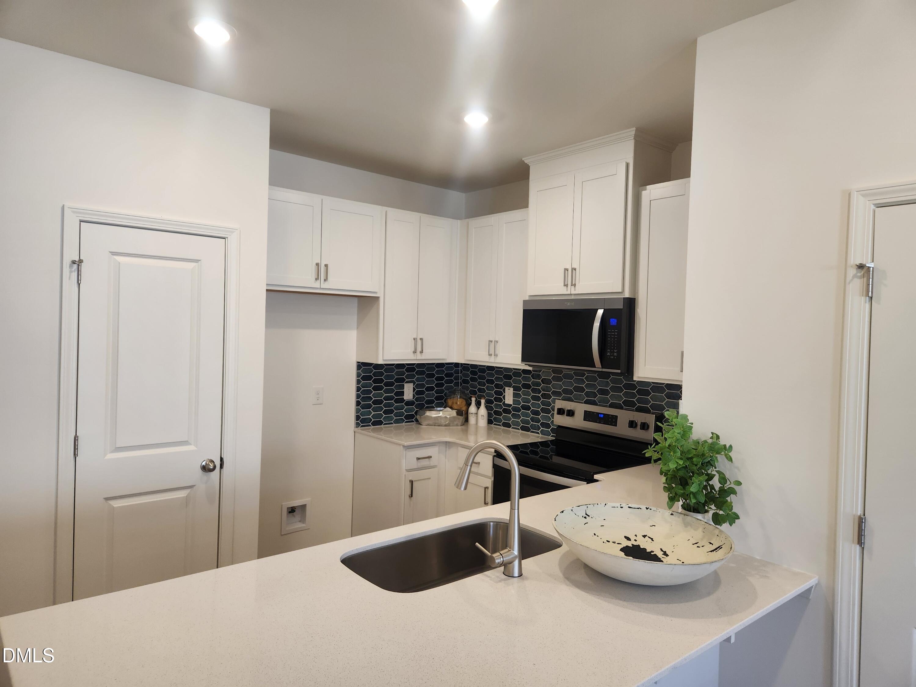 2204 Rabbitbrush Street Durham, NC 27704 - Photo 5 of 21 a kitchen with a refrigerator and a stove top oven