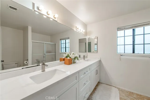 a bathroom with double vanity and a mirror