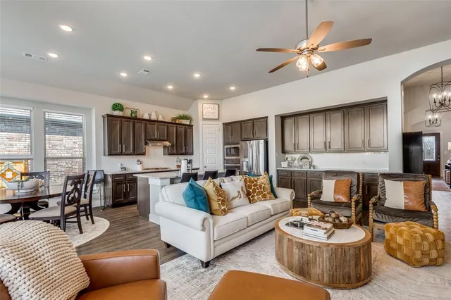 a living room with furniture kitchen view and a flat screen tv