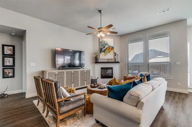 a living room with furniture a flat screen tv and a fireplace