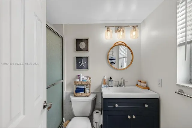 a bathroom with a toilet sink vanity and mirror