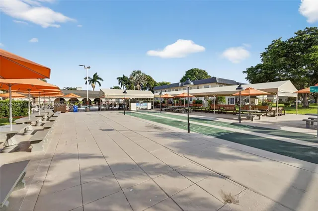 a view of a tennis ground with large trees