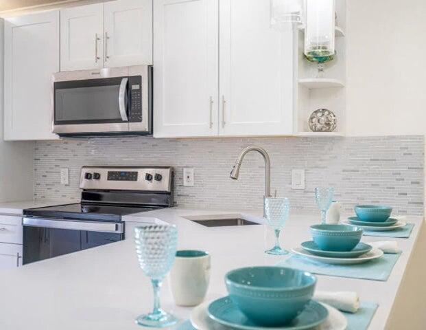 9284 Vista Del Lago, Unit 34F Boca Raton, FL 33428 - Photo 2 of 15 a kitchen with a stove and a sink