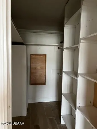 a view of walk in closet with empty racks