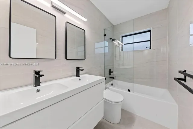 a bathroom with a double vanity sink mirror and bathtub
