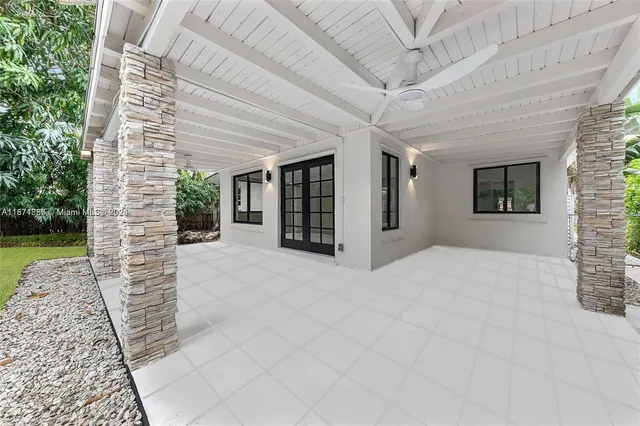 a view of an entrance to house with yard and sitting area