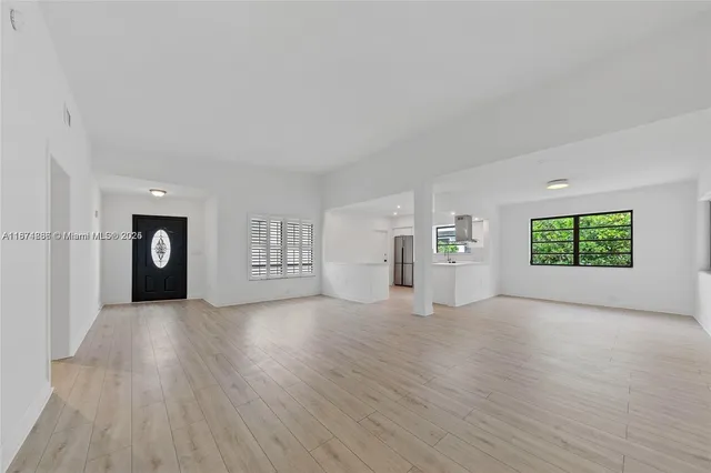 an empty room with windows and cabinet
