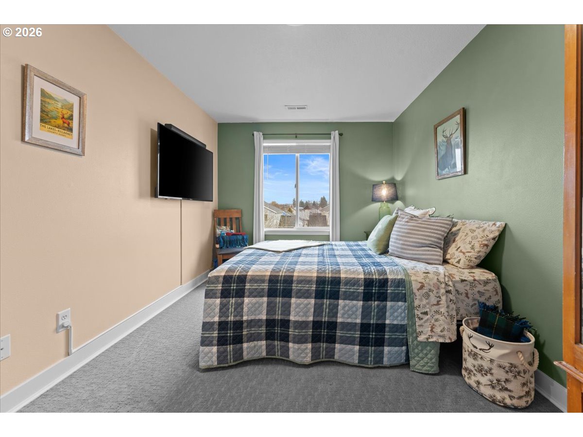 21123 Osburn Loop Fairview, OR 97024 - Photo 37 of 48 a bedroom with a bed and a flat screen tv