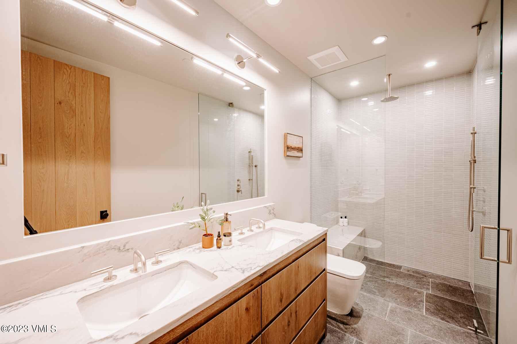 1033 Homestake Circle Vail, CO 81657 - Photo 12 of 30 a bathroom with a sink a toilet a large mirror and shower