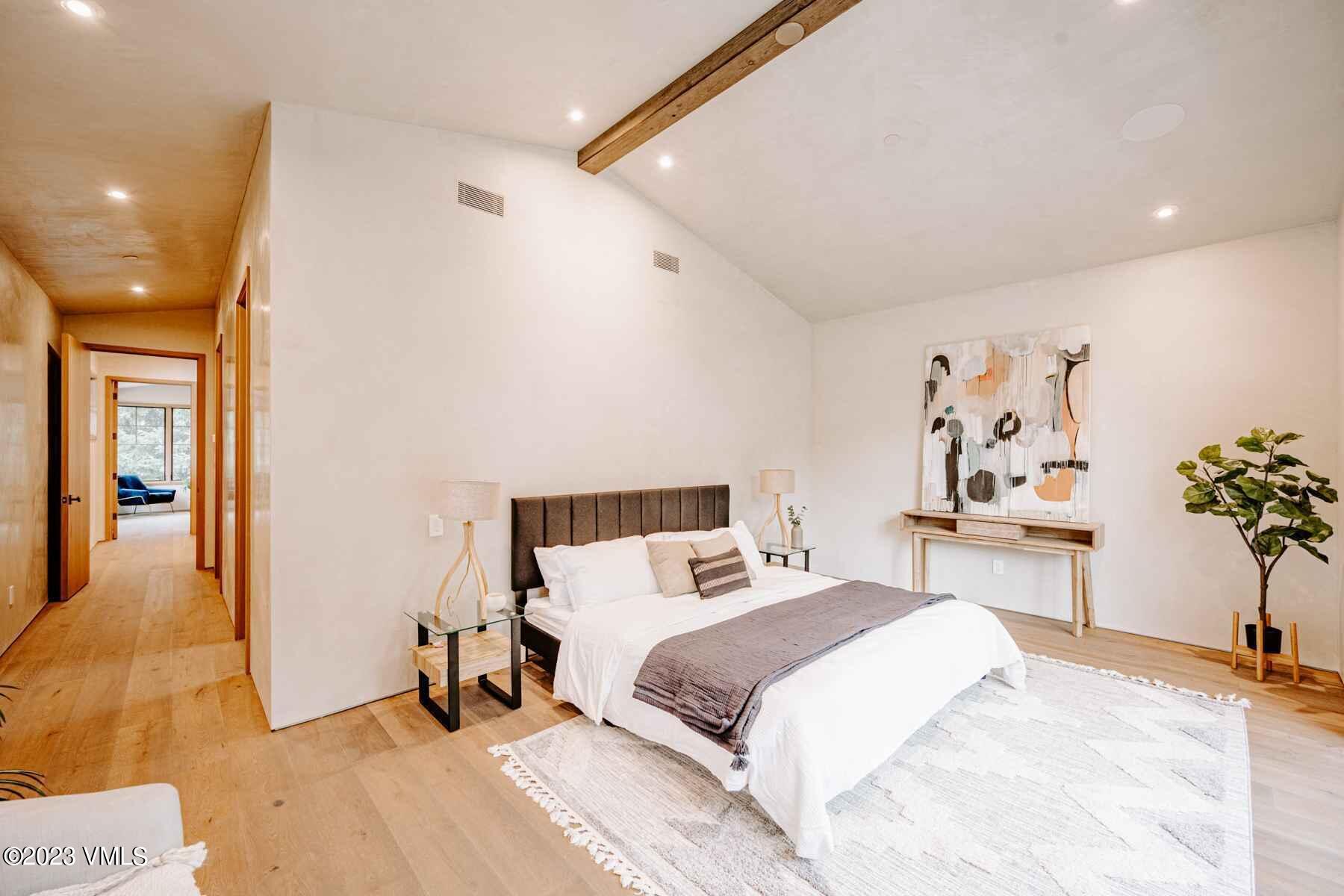 1033 Homestake Circle Vail, CO 81657 - Photo 23 of 30 a bedroom with a large bed and a chandelier