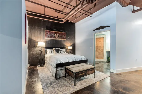 a bed sitting in a bedroom next to a window