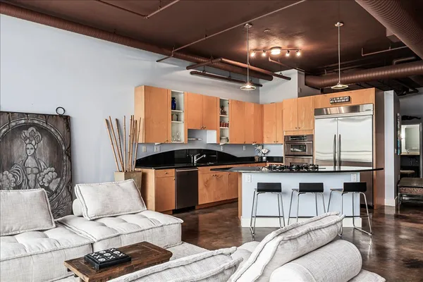 a kitchen with stainless steel appliances kitchen island granite countertop a sink and cabinets