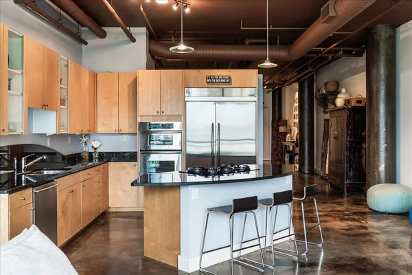 a kitchen with stainless steel appliances kitchen island granite countertop a sink and cabinets