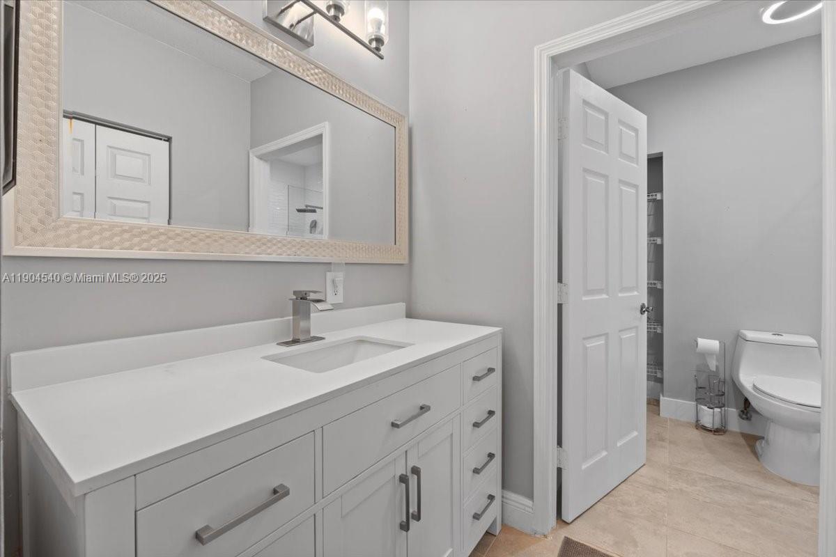 12720 Southwest 49th Court Miramar, FL 33027 - Photo 11 of 26 a bathroom with a sink toilet and mirror