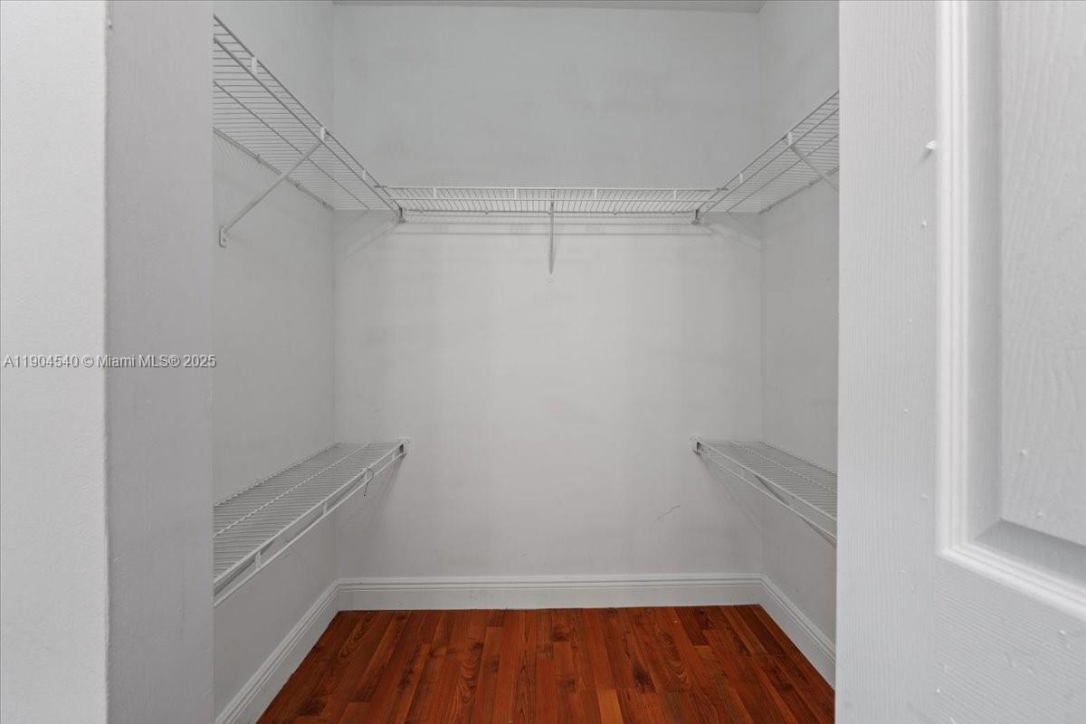 12720 Southwest 49th Court Miramar, FL 33027 - Photo 14 of 26 a view of walk in closet with wooden floor