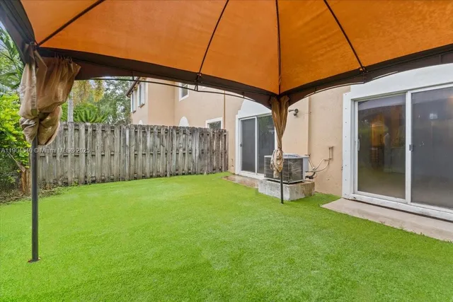 a view of a patio with table and chairs under an umbrella