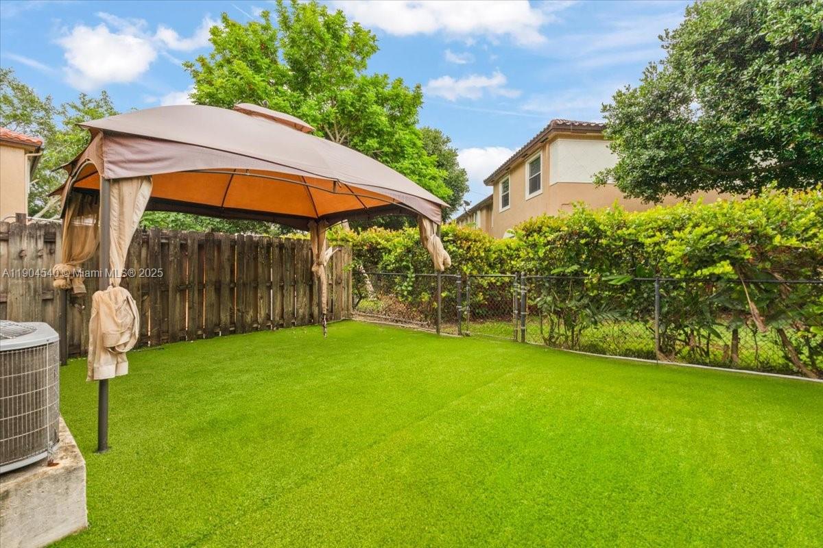 12720 Southwest 49th Court Miramar, FL 33027 - Photo 21 of 26 a view of a patio with table and chairs under an umbrella