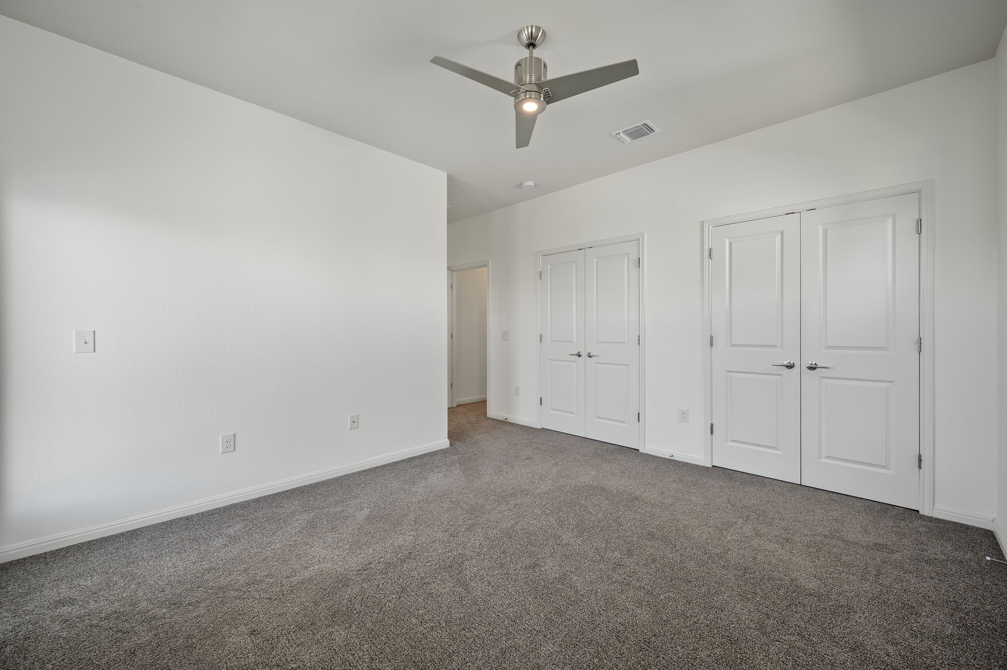 5809 Charles Merle Dr., Unit B Austin, TX 78747 - Photo 12 of 27 Unfurnished bedroom featuring carpet flooring, baseboards, visible vents, and two closets