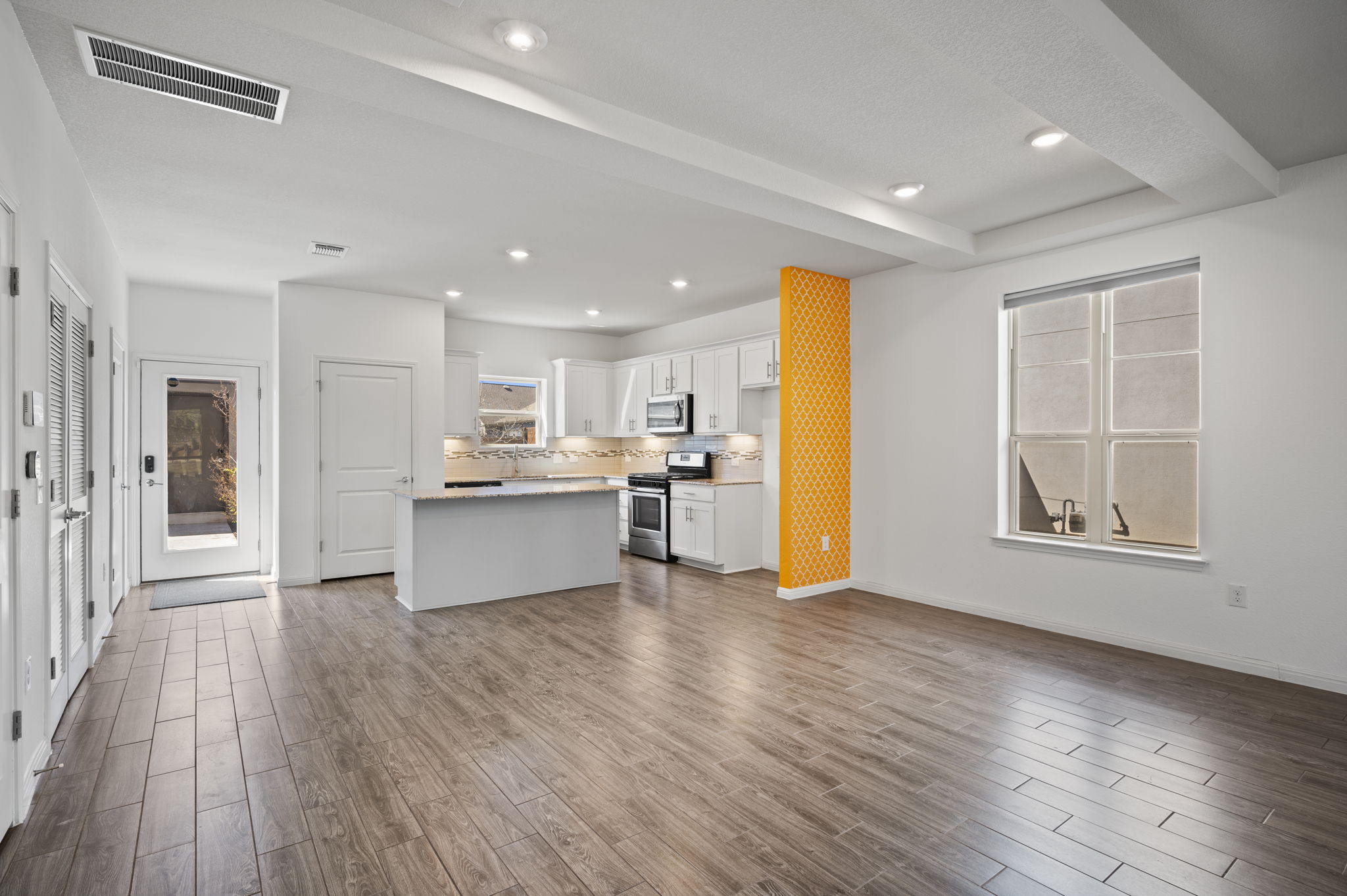 5809 Charles Merle Dr., Unit B Austin, TX 78747 - Photo 9 of 27 Kitchen featuring visible vents, appliances with stainless steel finishes, white cabinetry, and dark wood-type flooring