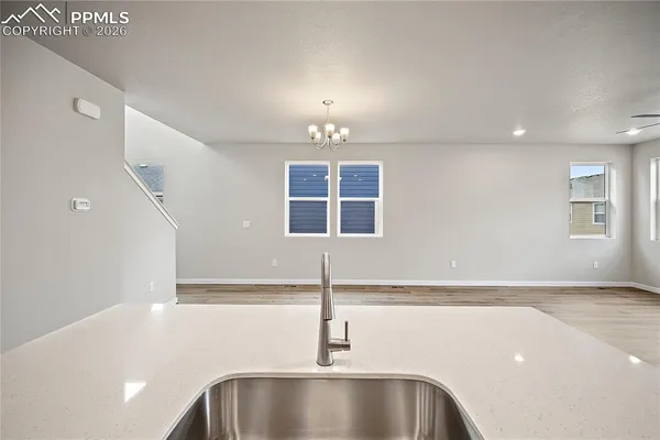 a view of a kitchen with a sink and chandelier
