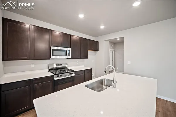 a kitchen with stainless steel appliances a sink stove and refrigerator