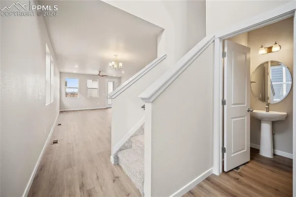 a view of a hallway with wooden floor and staircase