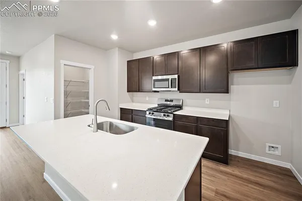 a kitchen with kitchen island a sink stainless steel appliances and cabinets