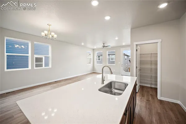 a kitchen with a sink a stove and hallway with wooden floor