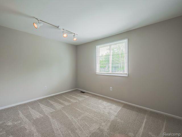 21728 Ruth Street Farmington, MI 48336 - Photo 39 of 54 Neutral-toned room featuring a single window with blinds, light gray wall paint, and gray patterned carpeting