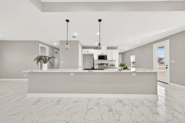 a kitchen with stainless steel appliances granite countertop a stove and a microwave