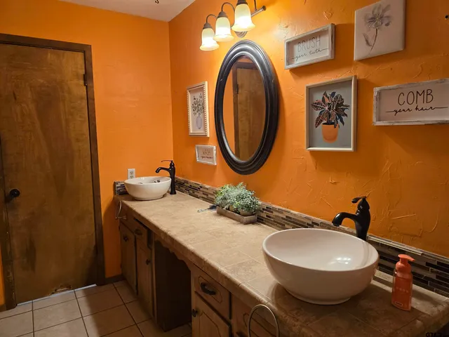 a bathroom with a granite countertop toilet sink and mirror