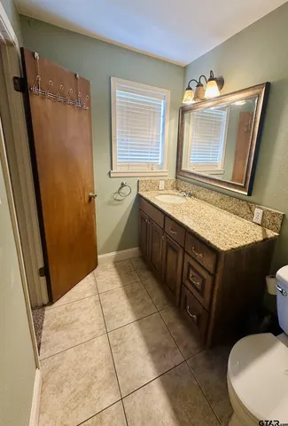 a spacious bathroom with a granite countertop sink toilet and shower