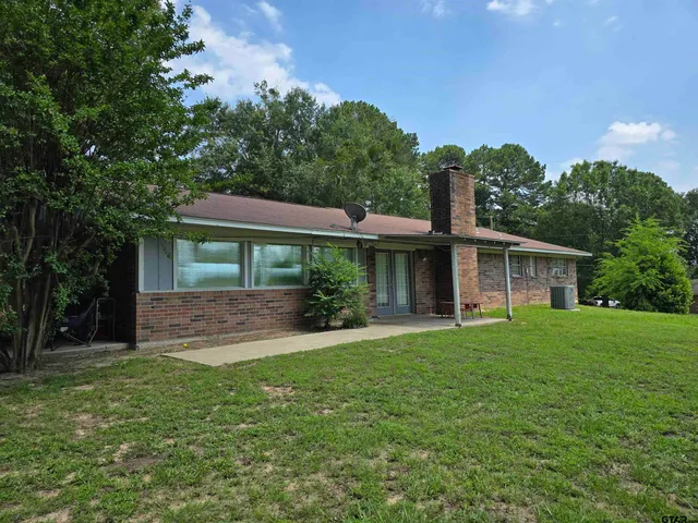 a front view of a house with a yard and trees