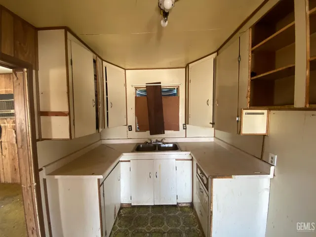 a view of a room with wooden floor and mirror