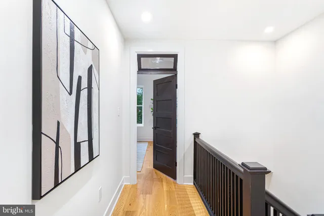 a view of a hallway with wooden floor and staircase
