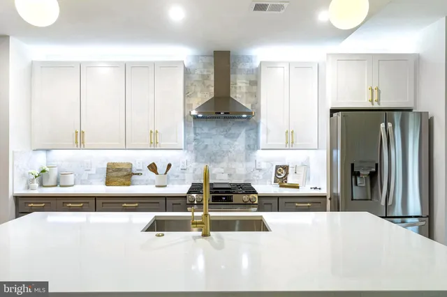 a kitchen with stainless steel appliances kitchen island granite countertop a refrigerator and a stove top oven