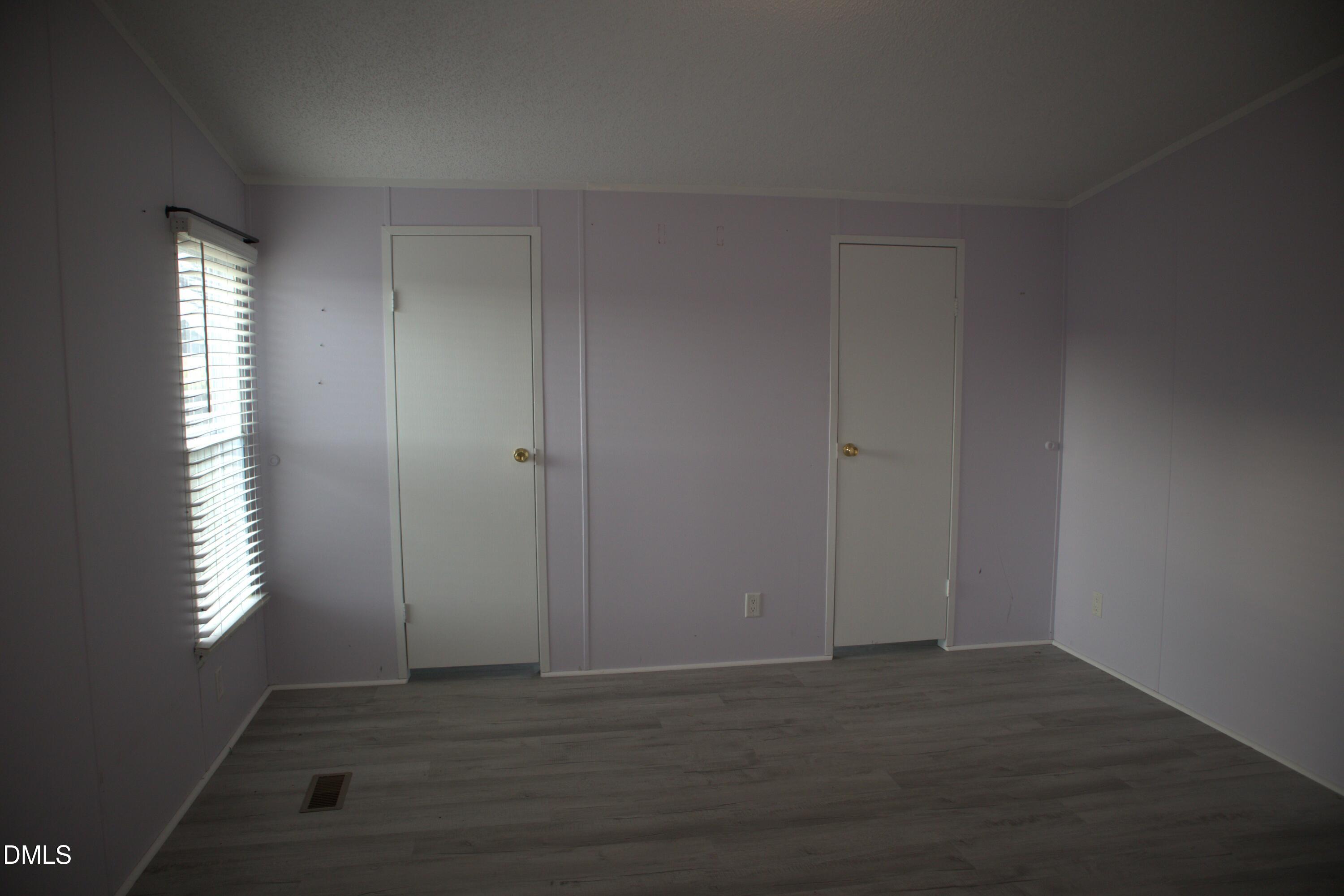 4762 Old Allensville Road Roxboro, NC 27574 - Photo 25 of 33 an empty room with wooden floor and windows