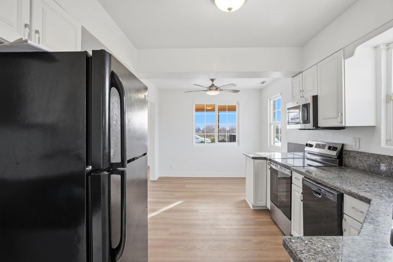 5333 Geer Road Turlock, CA 95382 - Photo 11 of 37 a kitchen with stainless steel appliances granite countertop a refrigerator a stove a sink and a microwave