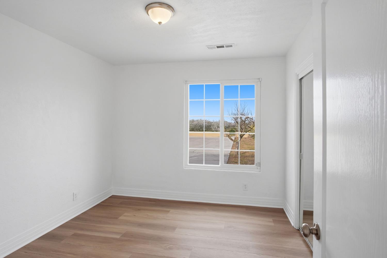 5333 Geer Road Turlock, CA 95382 - Photo 13 of 37 an empty room with wooden floor and windows