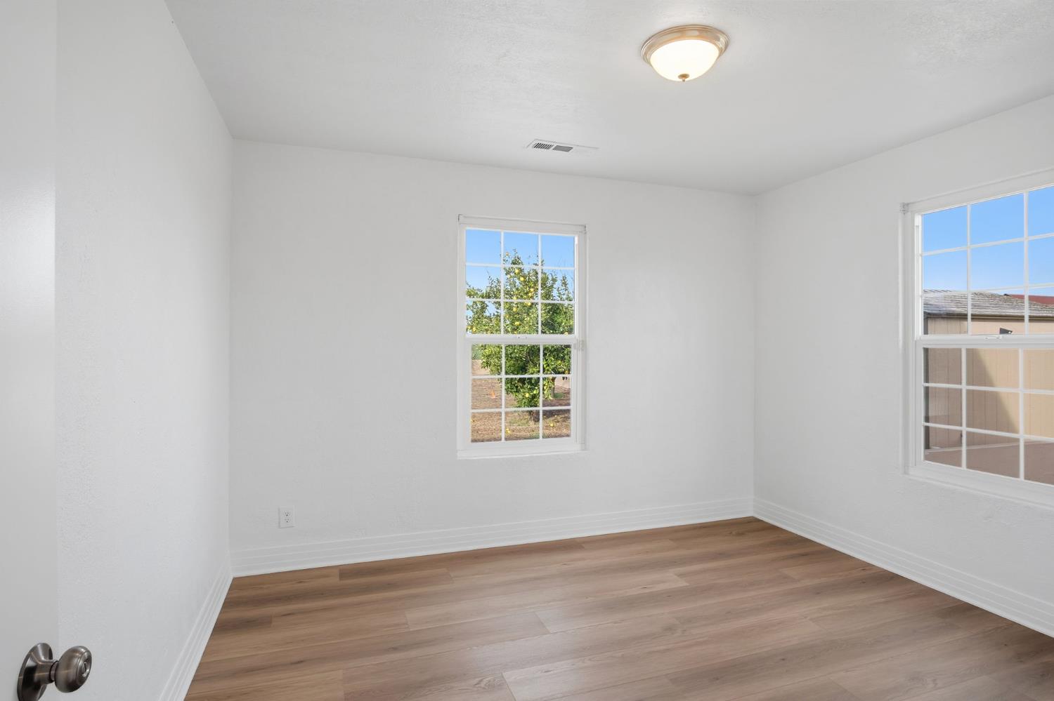 5333 Geer Road Turlock, CA 95382 - Photo 14 of 37 an empty room with wooden floor and windows