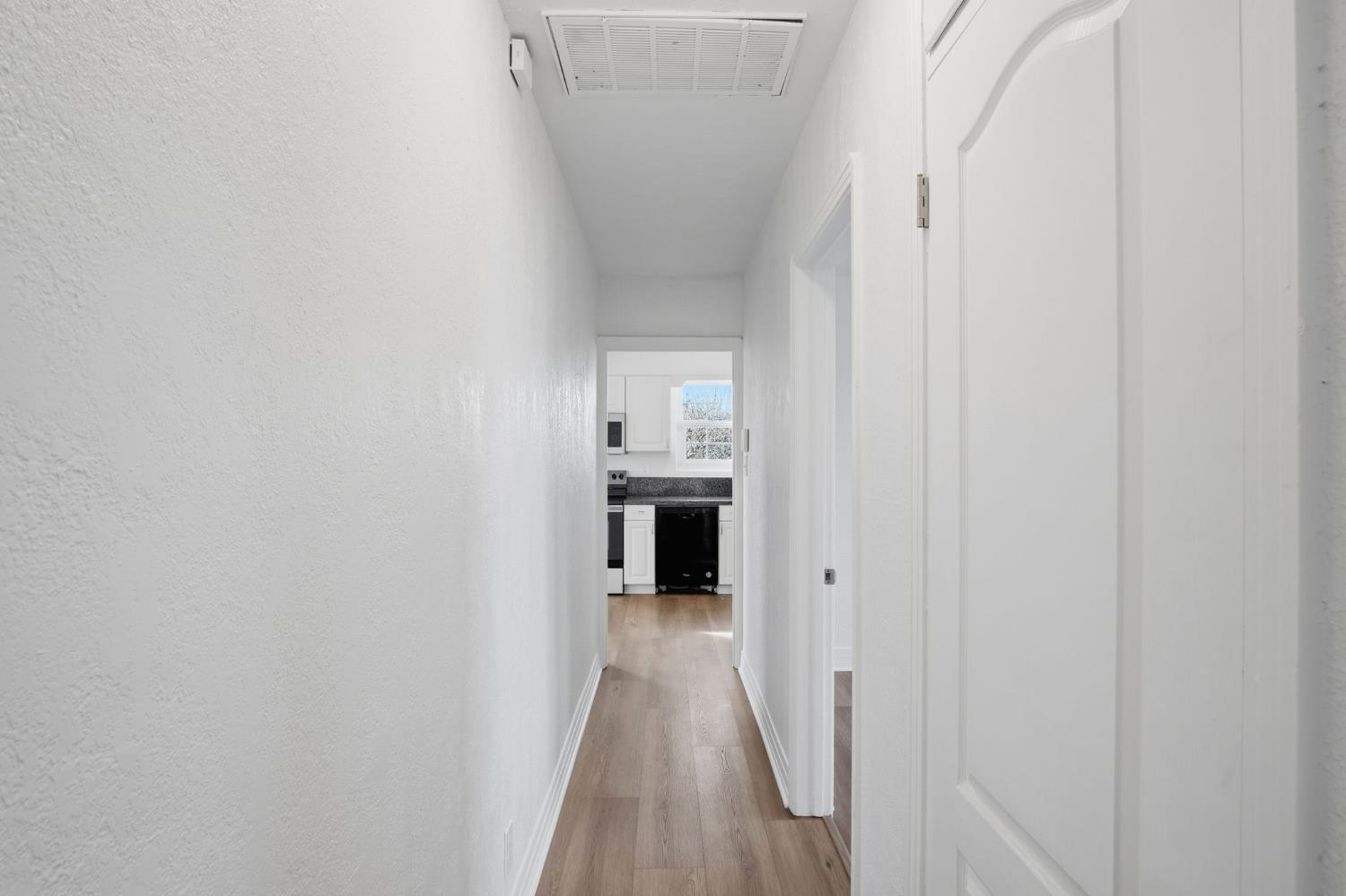 5333 Geer Road Turlock, CA 95382 - Photo 18 of 37 a view of a hallway with wooden floor and a kitchen