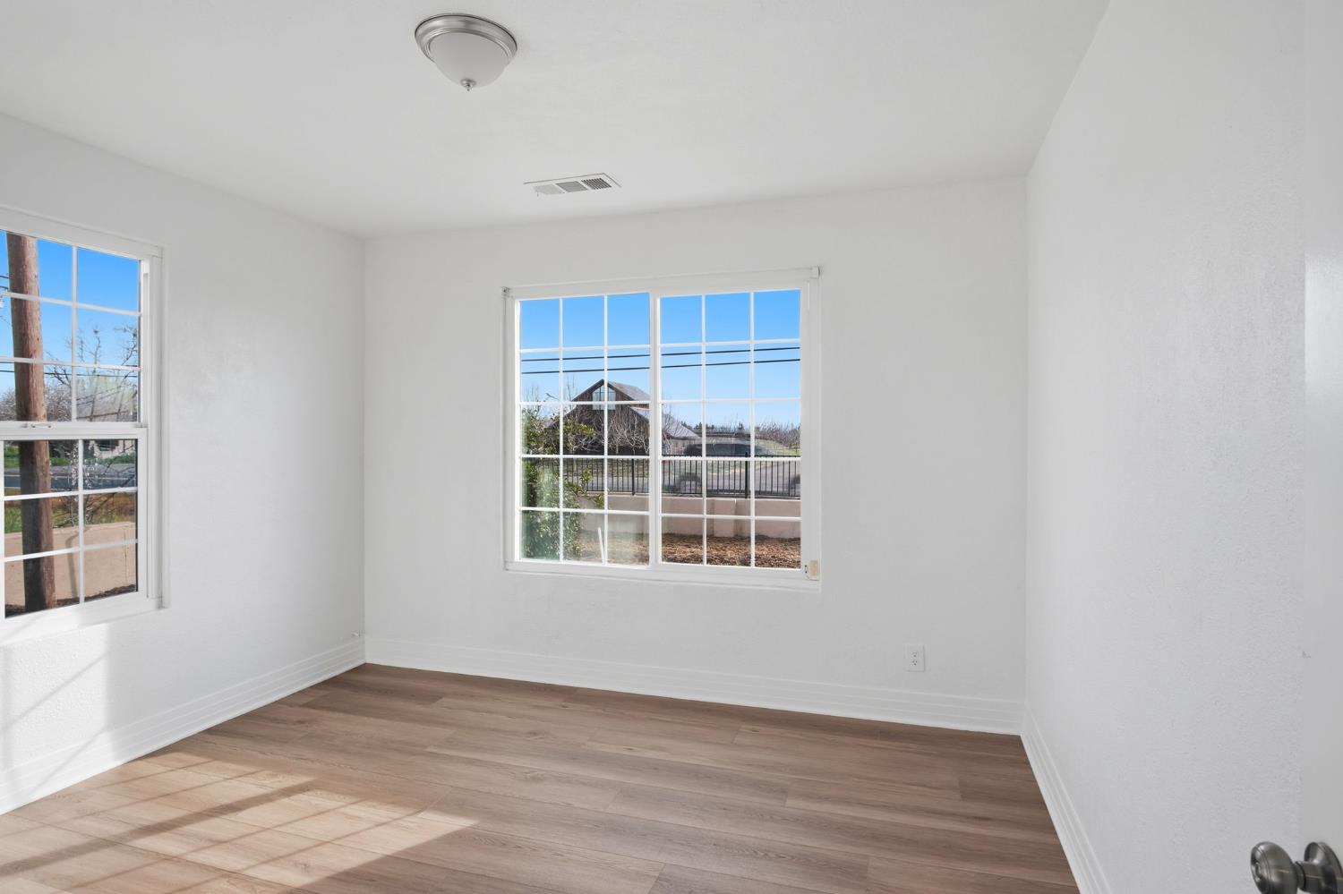 5333 Geer Road Turlock, CA 95382 - Photo 19 of 37 an empty room with wooden floor and windows