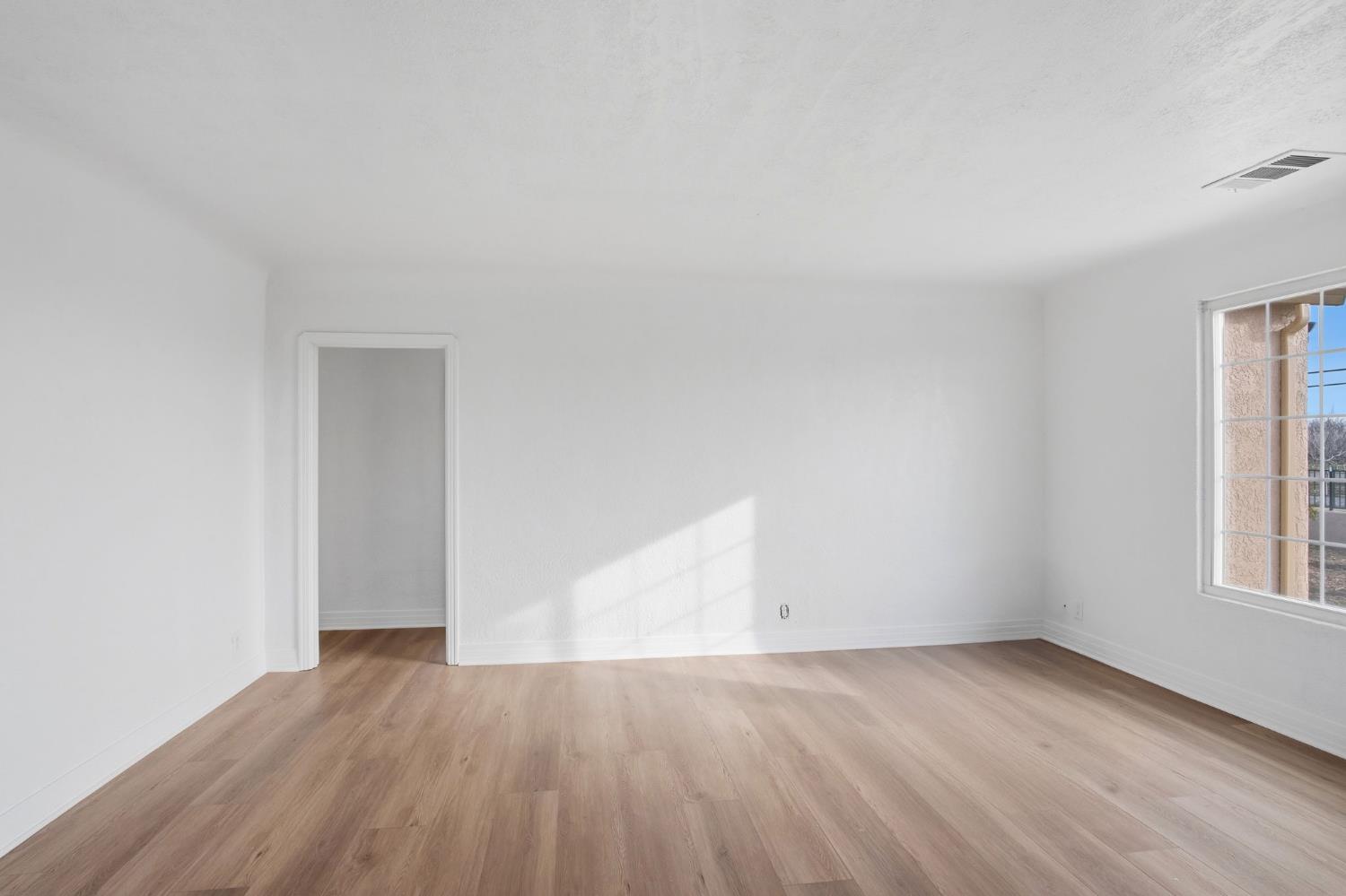 5333 Geer Road Turlock, CA 95382 - Photo 25 of 37 an empty room with wooden floor and windows
