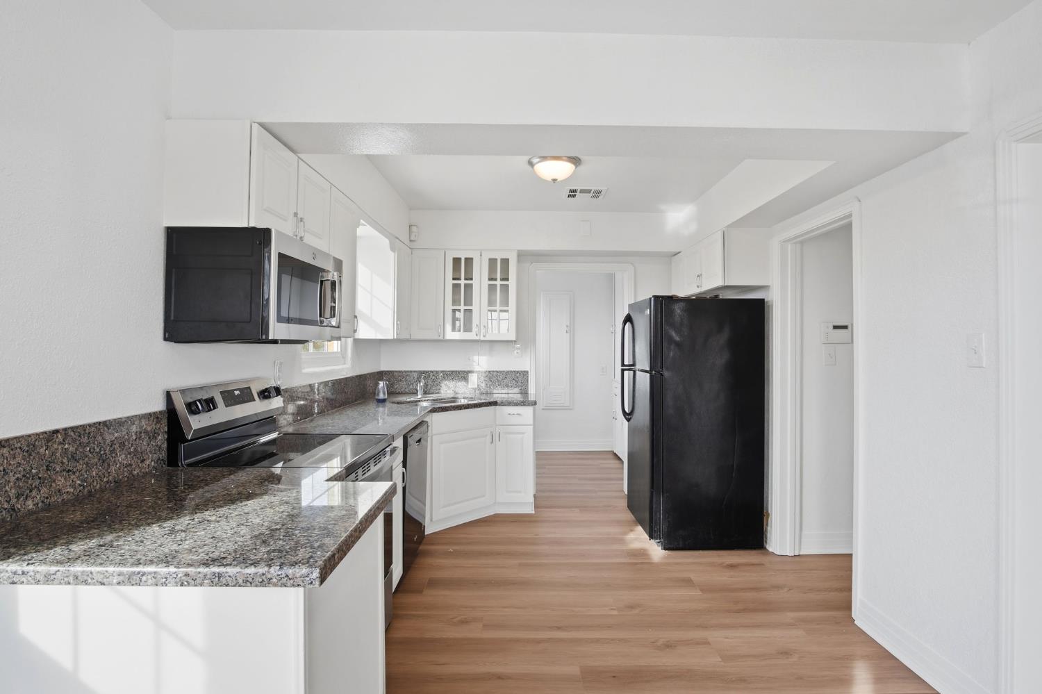 5333 Geer Road Turlock, CA 95382 - Photo 7 of 37 a kitchen with a refrigerator a microwave a sink and cabinets