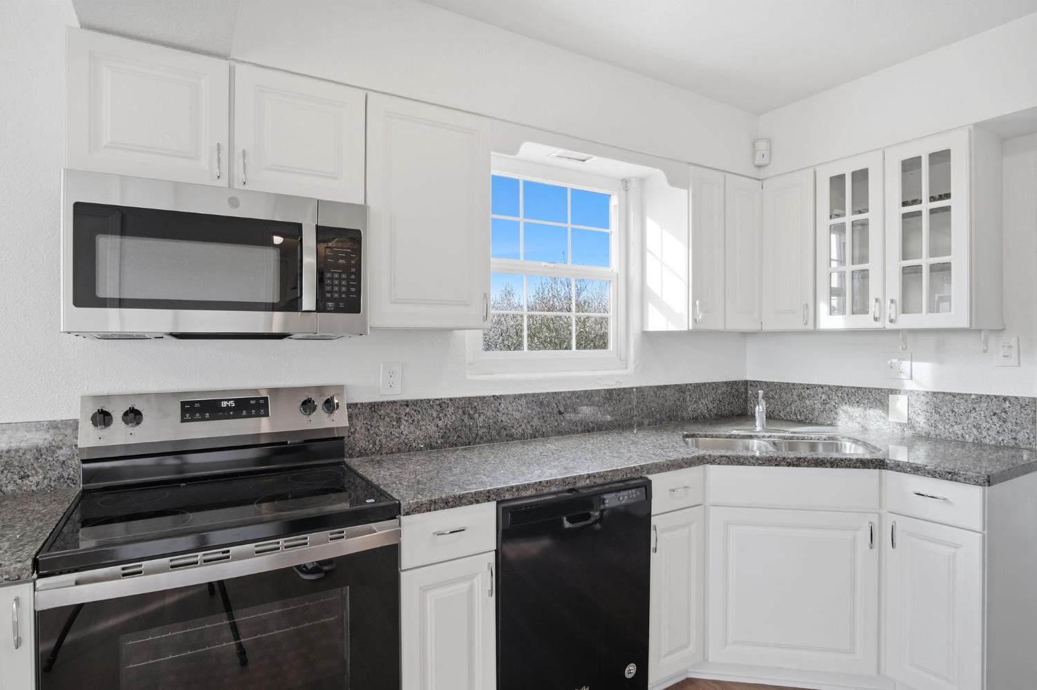 5333 Geer Road Turlock, CA 95382 - Photo 10 of 37 a kitchen with stainless steel appliances granite countertop a stove microwave and sink